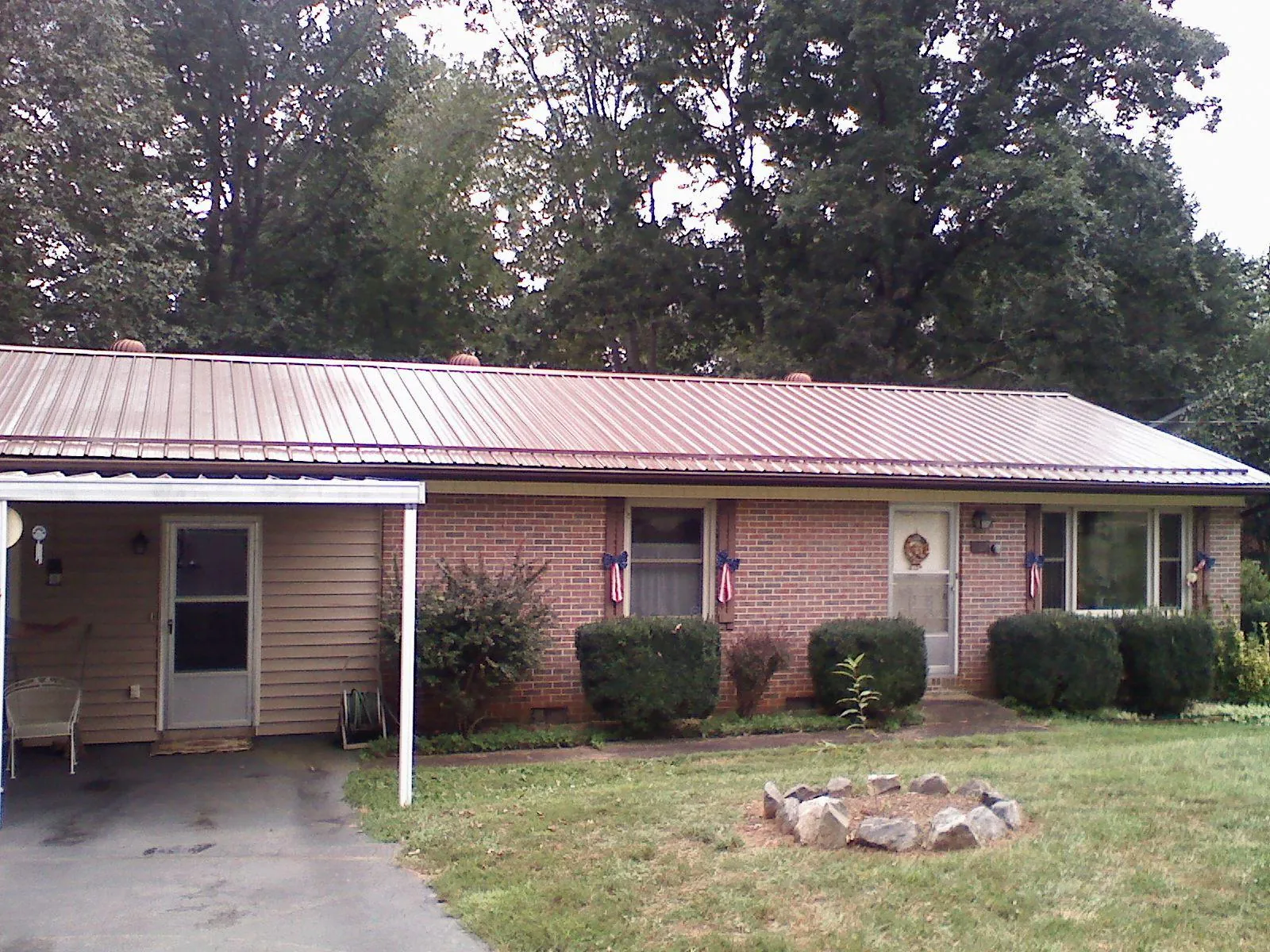 Bronze metal roof and carport on a brick ranch home — Roof Repair work by our crew in Bluffton